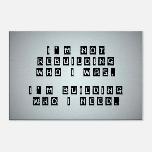 Horizontal motivational canvas print with white-on-black block text saying “I’m not rebuilding who I was. I’m building who I need.”


