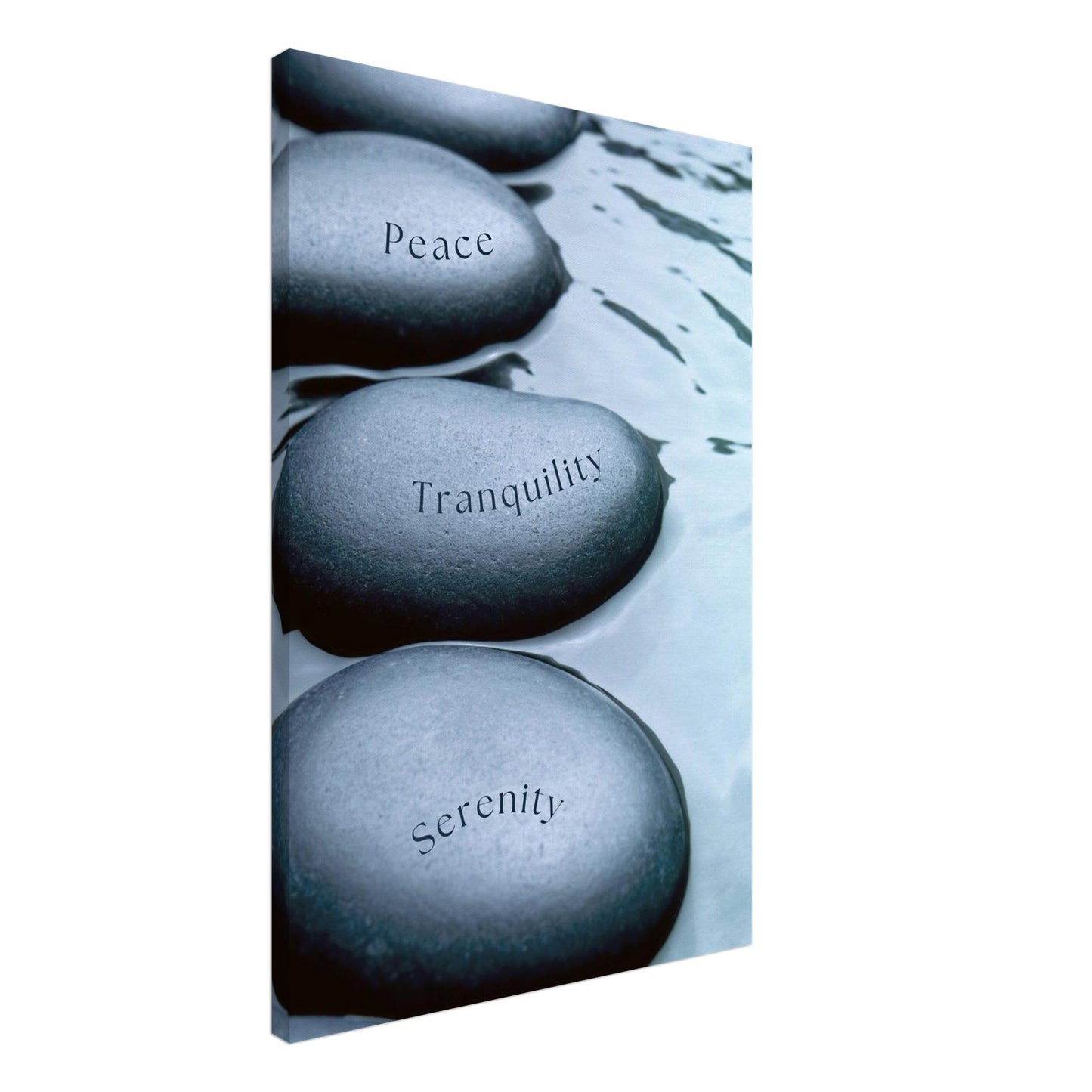 Minimalist canvas featuring smooth stones with words “Peace,” “Tranquility,” and “Serenity” on charcoal and white backdrop

