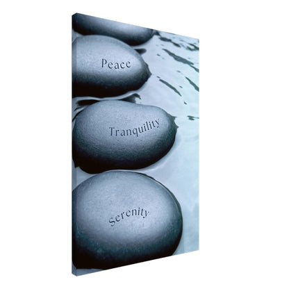 Minimalist canvas featuring smooth stones with words “Peace,” “Tranquility,” and “Serenity” on charcoal and white backdrop

