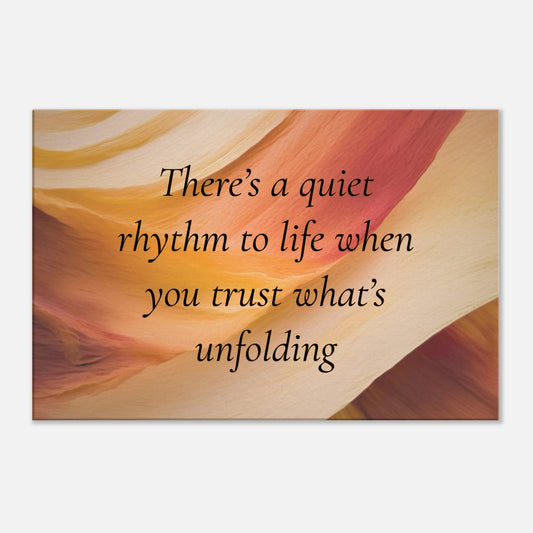 Canvas wall art with a quote "There's a quiet rhythm to life when you trust what's unfolding" on an abstract background with warm red, cream and caramel colors.  The canvas is placed on a white wall background. 
