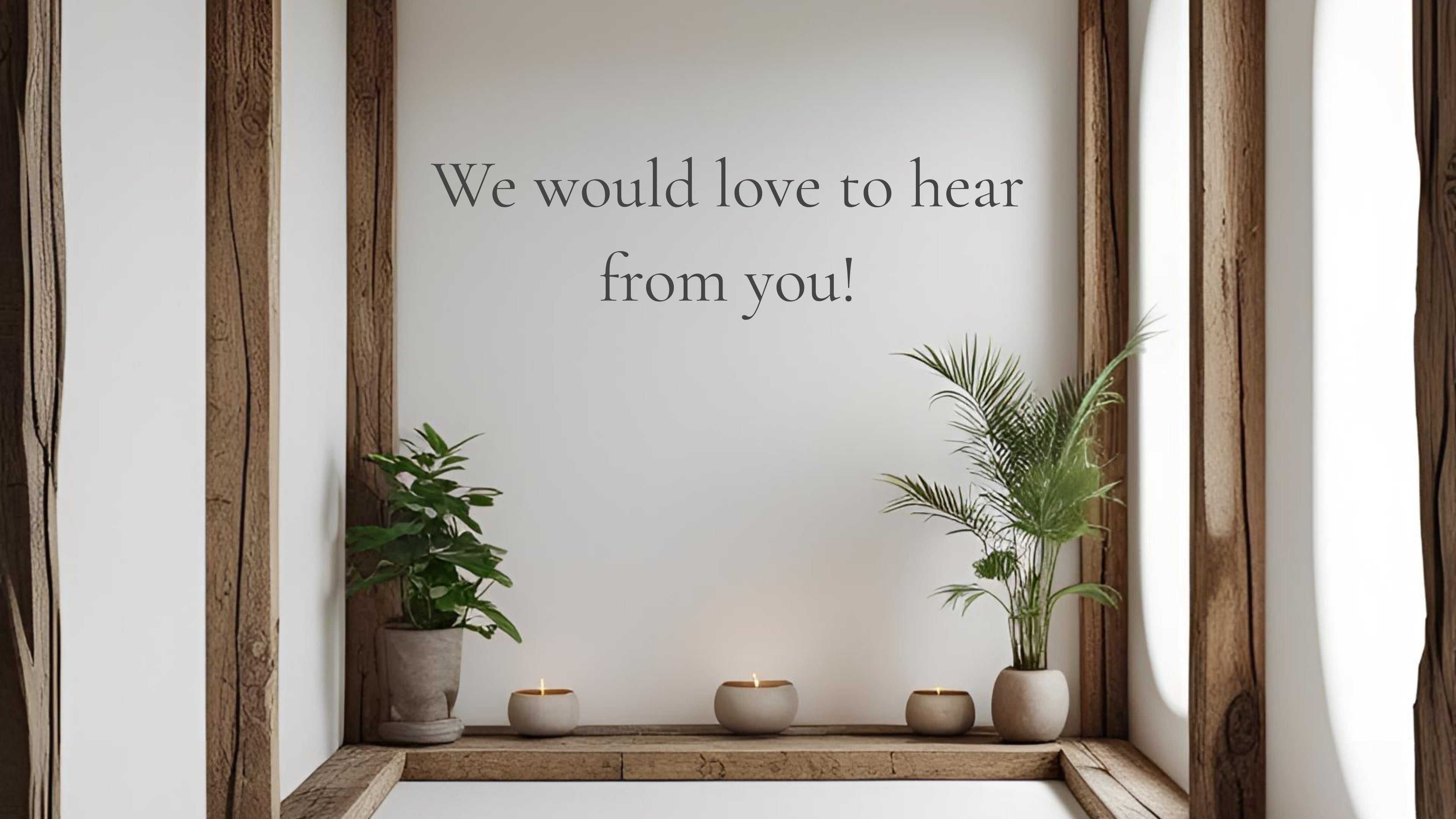 Meditation space with candles and plants, featuring a message 'we would love to hear from you' on a white wall