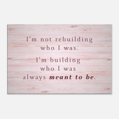 Inspirational canvas wall art with quote “I’m building who I was meant to be” on pink wood background

